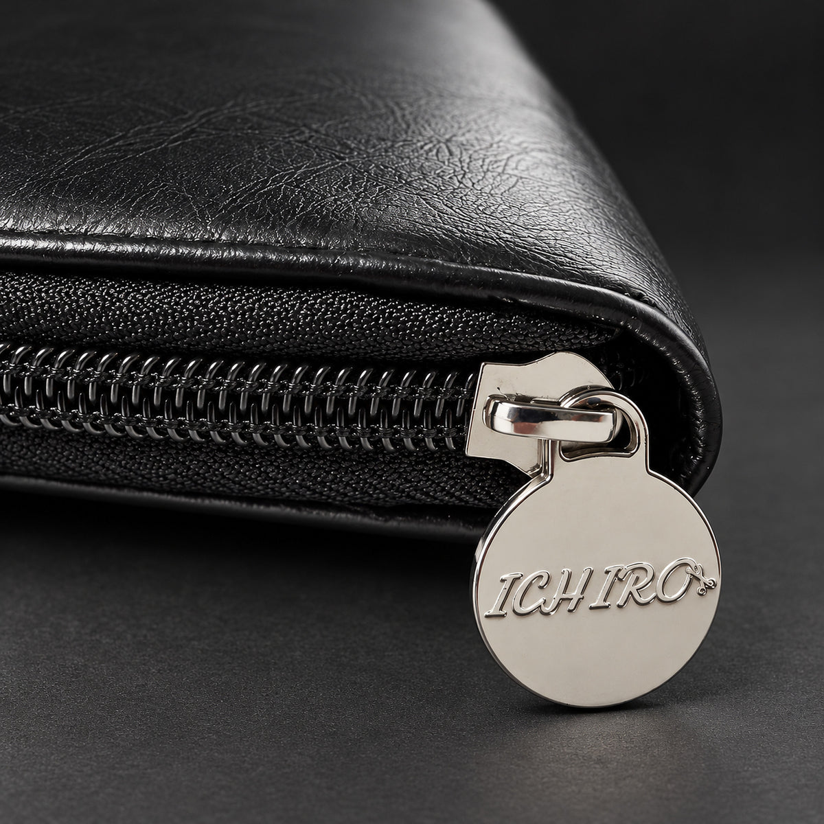 Polished Ichiro zip pull with engraved logo on the black travel case